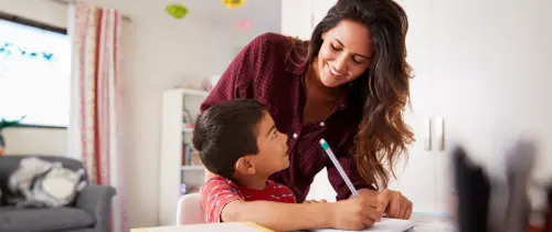 A woman and a child collaborate on writing, sharing ideas and creativity in a nurturing environment.