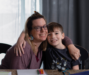 Mother and her son hugging and smiling at the camera